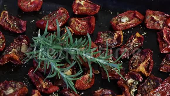 晒干的西红柿与香料和大蒜在烤片上上面躺着新鲜的迷迭香视频的预览图