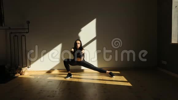 在光线不好的房间里一个运动的女人在做侧冲视频的预览图