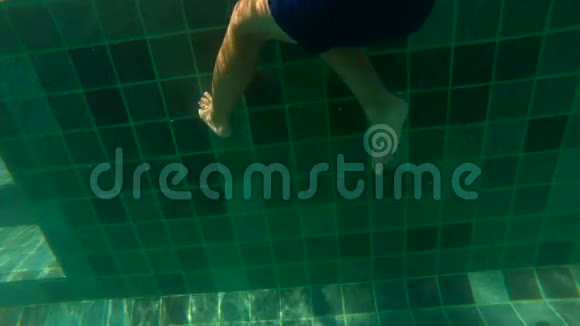一个小男孩在水下拍摄的超HD慢动作学习如何在游泳池里游泳幼儿男孩潜入游泳池拉视频的预览图