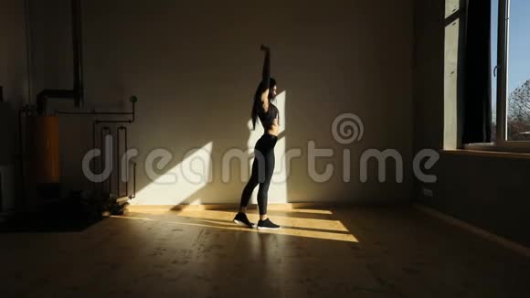 平视着画室里站在弓步姿势的迷人女子视频的预览图