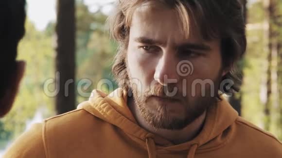 一个长头发的愤怒家伙在树林里和朋友吵架视频的预览图