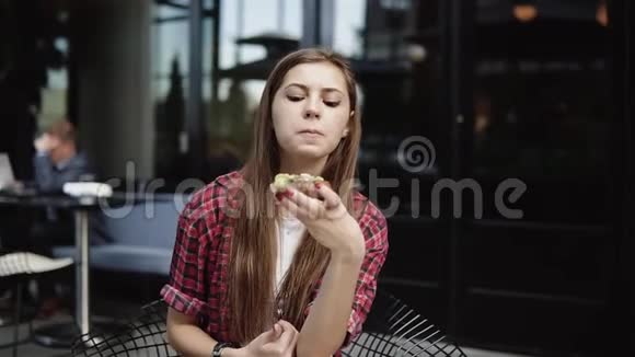 年轻可爱的女人刚在城市咖啡馆吃了美味的三明治视频的预览图