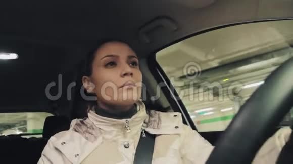 担心穿着白色夹克的年轻女子驾驶汽车在地下停车视频的预览图