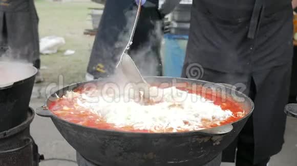 有汤的铸铁锅木炉上的平底锅户外烹饪火酿制食品大锅饭烹饪食品视频的预览图