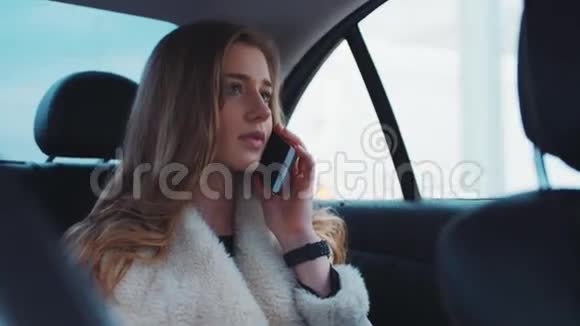 漂亮漂亮的商务女性和她的朋友在电话里交谈在开车上班时微笑视频的预览图