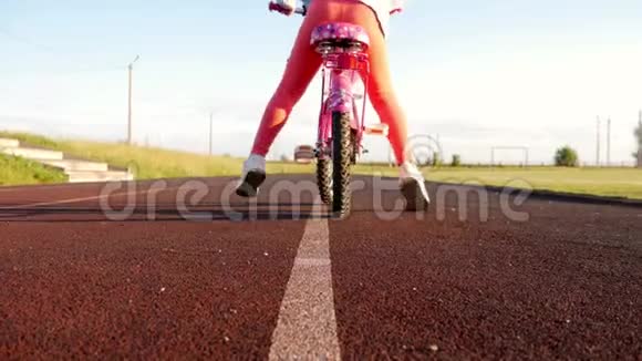 小女孩学骑自行车近距离拍摄年轻女孩骑自行车户外生活方式视频的预览图