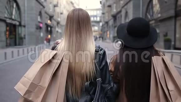 两个带购物袋的步行妇女的后景视频的预览图