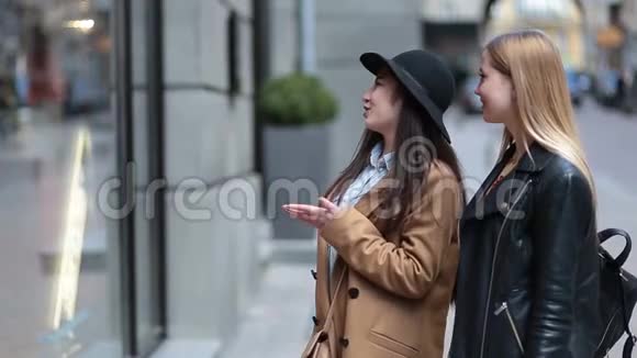 两个年轻女子看着服装店的橱窗视频的预览图