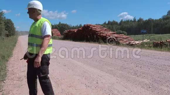 压力很大的伐木工人走在成堆的木头旁边视频的预览图