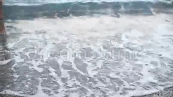 男人晒黑的腿在沙滩上奔跑海上行走的人视频的预览图