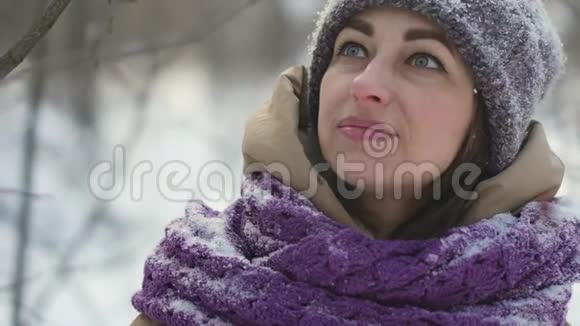 一场大雪中快乐的美女正在冬天的森林里散步视频的预览图