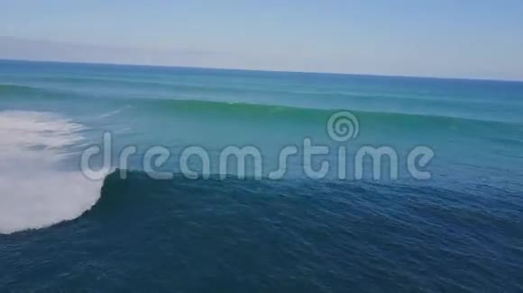 在阳光明媚的夏日在蓝色绿松石海水中在巨大的白色泡沫波浪中冲浪在4k空中海景无人机的视野中视频的预览图