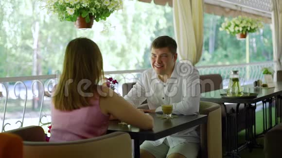 年轻夫妇在餐厅露台上交谈视频的预览图