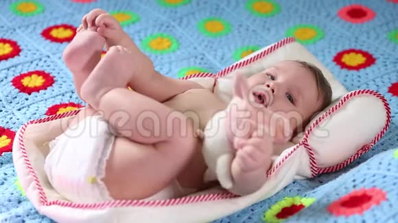 美丽的微笑宝宝一个漂亮的小宝宝躺在床上对着相机微笑轻轻地聚焦着视频的预览图