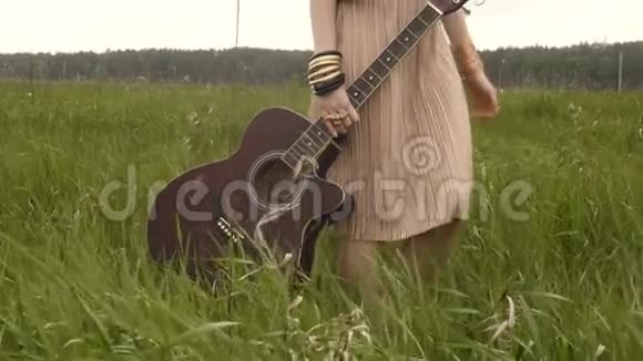 无法辨认的女人带着吉他在现场视频的预览图