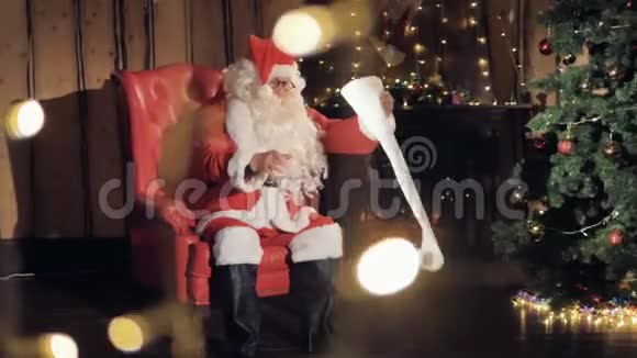 圣诞前夜圣诞老人在壁炉边看礼物清单4K视频的预览图