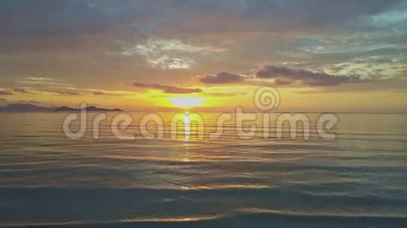 海浪在宁静的海洋海滩上太阳从地平线上升起视频的预览图