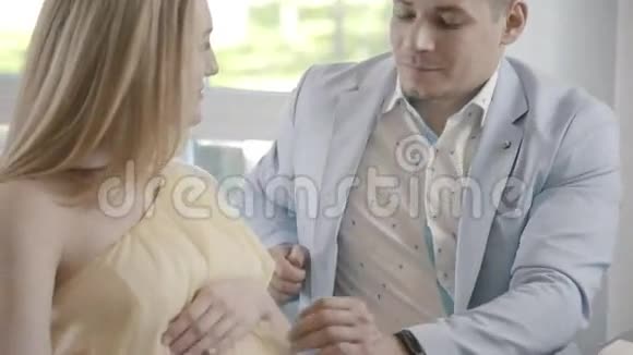 未来的父亲把手放在怀孕妻子的肚子上视频的预览图