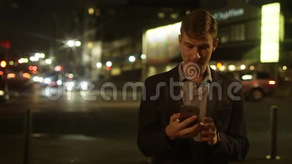 年轻人正在大街上翻阅一条短信视频的预览图