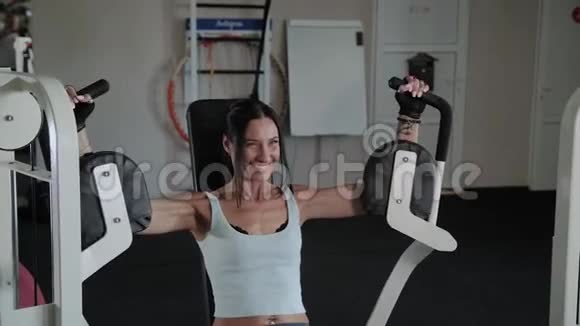 美丽的运动女性在模拟器上训练胸肌视频的预览图