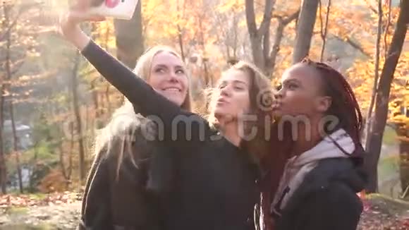 开朗多元文化的女朋友正在自拍做有趣的脸其中一个是美国黑人视频的预览图
