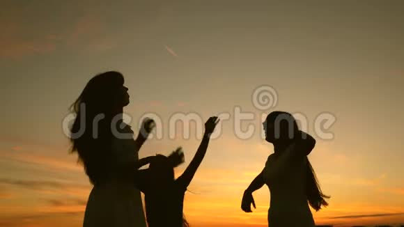 快乐的女孩在海滩上跳舞湖边聚会孩子们跳舞慢动作美丽的女孩在听音乐视频的预览图