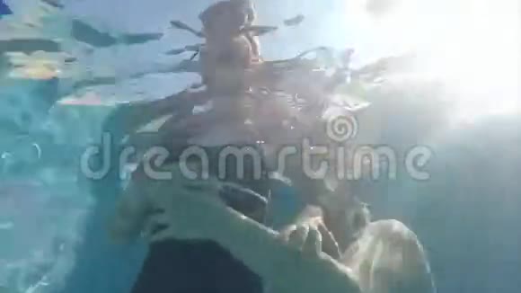 在水下母亲在游泳池里抚养女儿视频的预览图