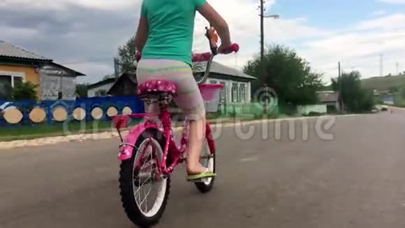 小女孩学骑自行车近距离拍摄年轻女孩骑自行车户外生活方式视频的预览图