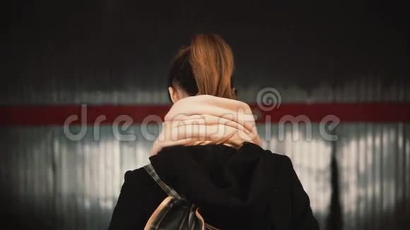 年轻女子站在地铁站台上背景是经过火车等待地铁上班的女孩视频的预览图