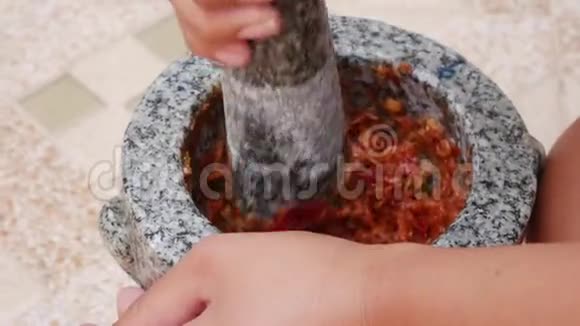 泰国辣椒和大蒜用杵在石臼里敲打准备泰国汤酱的女人汤姆山药关上门4k视频的预览图