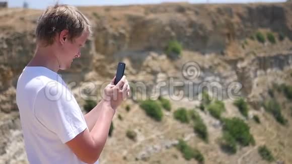 一个站在岩石上的人在电话里拍了张照片高清1920x1080慢动作视频的预览图