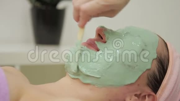 美容师在美容院给女人戴上面具视频的预览图