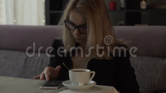 美女在背景咖啡杯上的屏幕手机上输入信息视频的预览图
