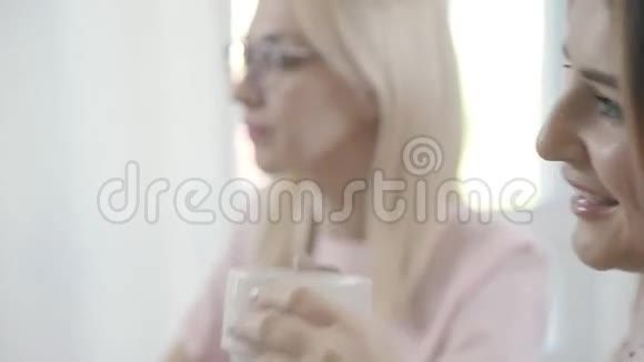 一位身材魁梧的年轻女子喝茶看着同病相怜的人视频的预览图