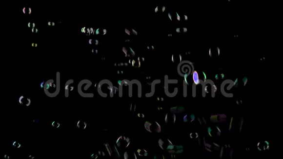 肥皂泡以不同的颜色飞舞和褪色黑色背景视频的预览图