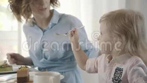 穿衬衫的可爱宝宝在和父母一起吃饭视频的预览图