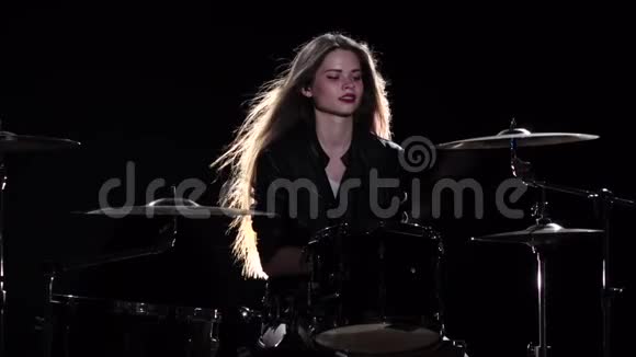 鼓手女孩开始演奏充满活力的音乐她微笑着黑色背景慢动作视频的预览图