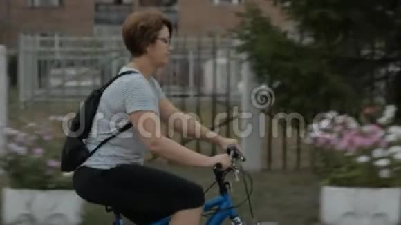 戴眼镜的女人骑着自行车在户外翻滚视频的预览图