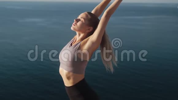 女人在早晨做运动和伸展运动看海慢动作视频的预览图