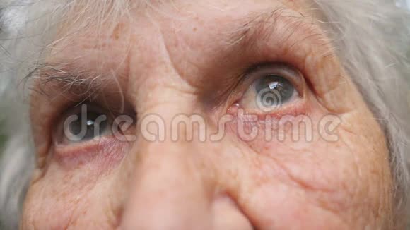 老奶奶抬头的肖像闭上眼睛一个有皱纹的老年妇女视频的预览图