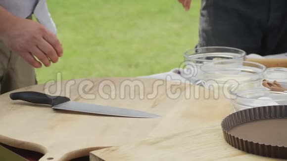 厨师用刀切熟李子在木切割板上视频的预览图