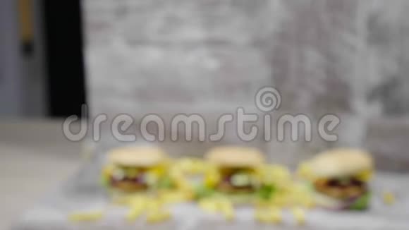 放大从不关注美味的家做汉堡旁边的薯条木制背景视频的预览图