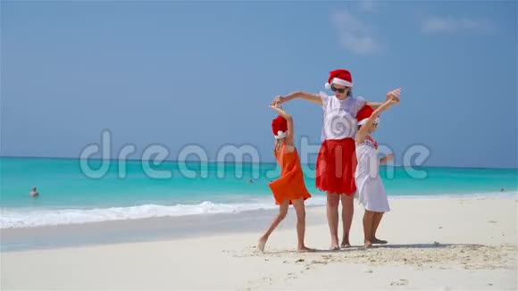 圣诞老人海滩上的小女孩和年轻母亲视频的预览图