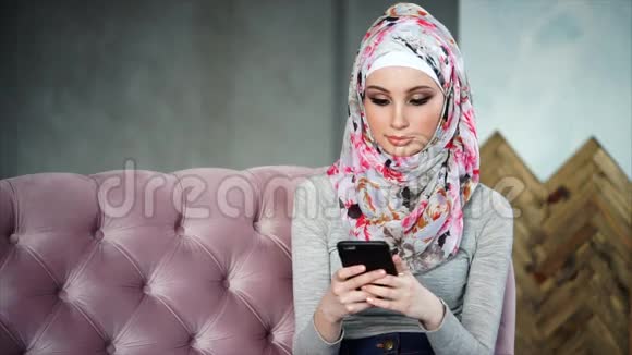 一个现代的阿拉伯女人在她的手机上与她的朋友交流视频的预览图