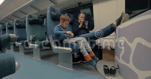 母亲和孩子在火车上使用电子产品视频的预览图