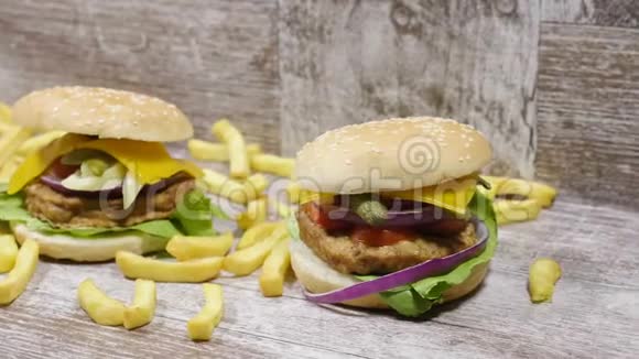 在法式炸薯条上放在美味汉堡旁边的木制背景上视频的预览图
