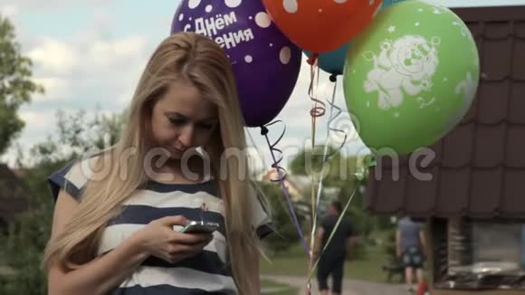 女孩拿着气球在智能手机上留言视频的预览图