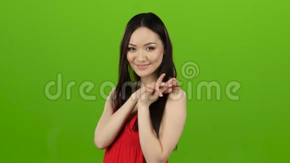 穿着红色裙子的女孩调情亲吻和微笑绿色屏幕视频的预览图