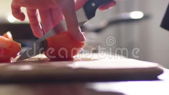 一个年轻的女人正在厨房里做沙拉她把红色多汁的番茄切成许多小块视频的预览图