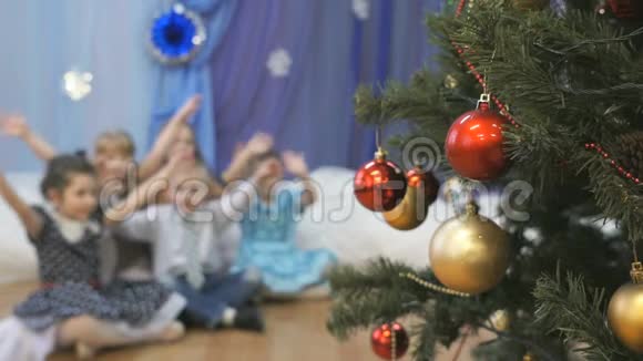 模糊的孩子们在圣诞树旁挥舞着手视频的预览图